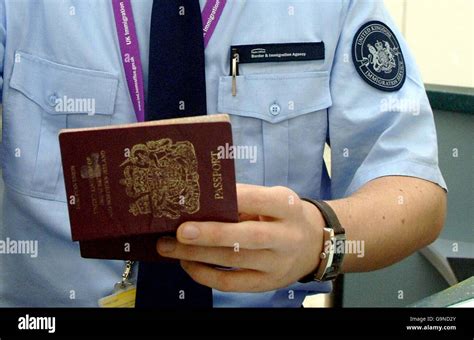An Immigration Officer Wearing A New Uniform Checks A Passport From A