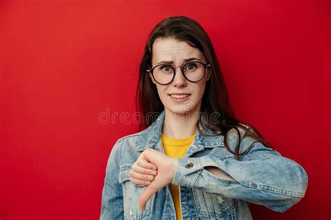Dissatisfied Young Woman In Eyeglasses Showing Thumbs Down Gesture