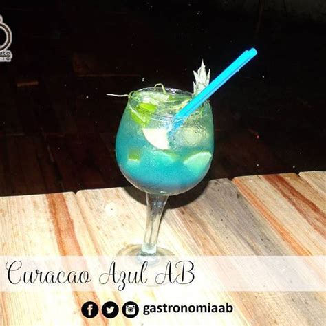 A Blue And Green Drink Sitting On Top Of A Wooden Table With A Straw In It