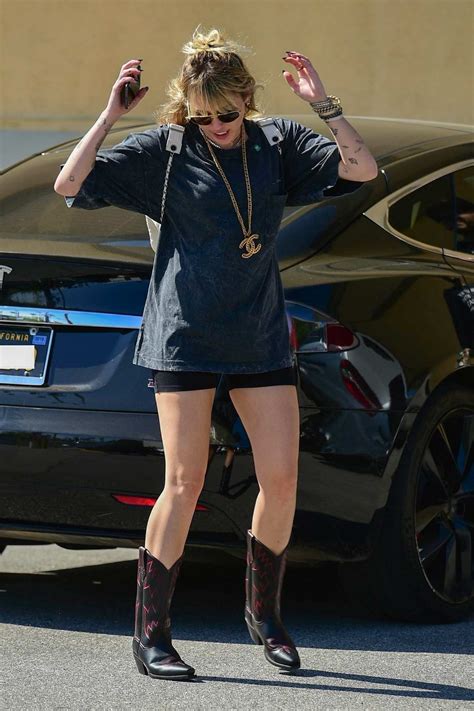 Miley Cyrus Rocks A Baggy Tee With Black Shorts And Cowboy Boots While