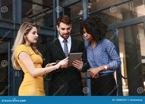Corporate Professionals Discussing Work Using Digital Tablet Stock