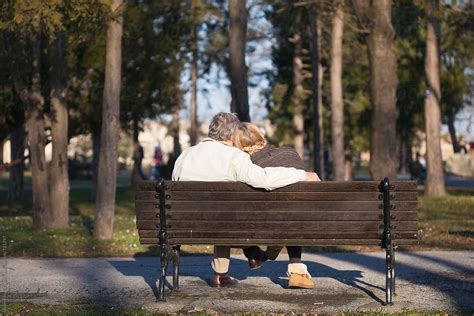 Couple In Love Sitting On A Park Bench Del Colaborador De Stocksy