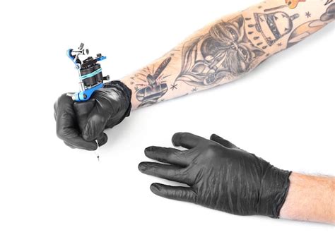 Premium Photo Tattooist Hands In Black Gloves With Tattoo Machine