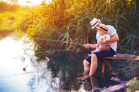 Padre Con Su Pequeño Hijo Están Pescando Sentado En Un Muelle De Madera