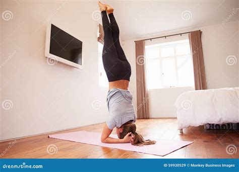 Woman Doing Yoga Fitness Exercises On Mat In Bedroom Stock Image