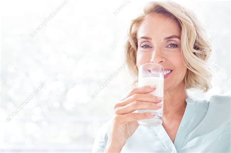 mature woman smiling with drink stock image f020 7463 science photo library
