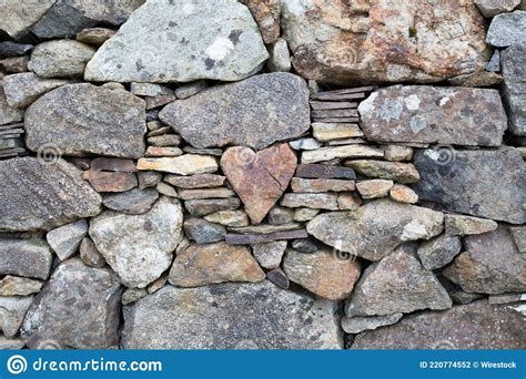Heart Shaped Stone Stuck In The Middle Of A Wall With Other Small And