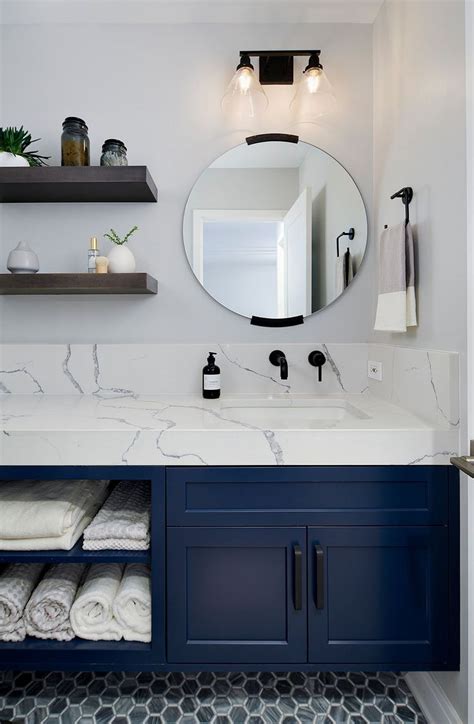 A Bathroom With Marble Counter Tops And Blue Cabinets Along With White