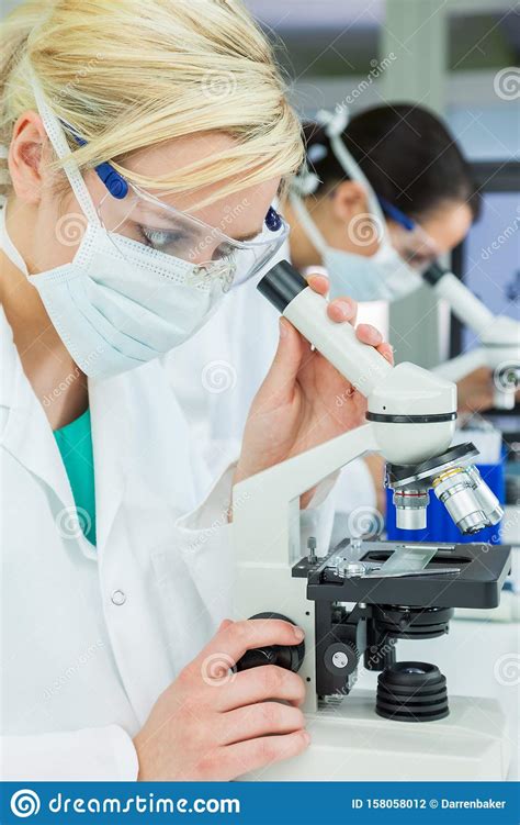 Female Scientific Research Team Scientists Using Microscopes In A