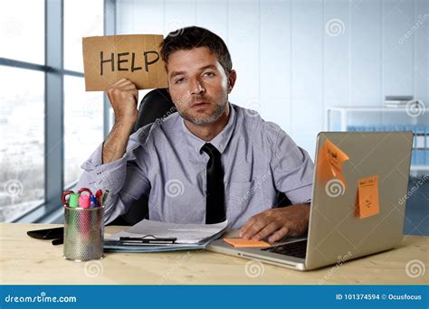 Businessman Suffering Stress Working At Computer Desk Holding Sign