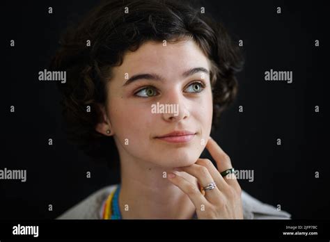 Portrait Of Confident Beautiful Teenage Girl Looking Away And Daydreaming On Black Background