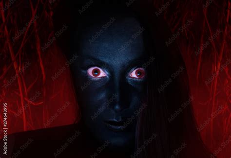 Scary Face Of A Witch With Dark Skin And Red Eyes Staring With Burning