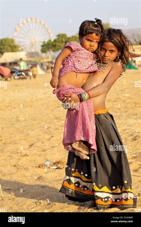 A Young Girl Carries A Baby At The Pushkar Fair In Rajasthan India