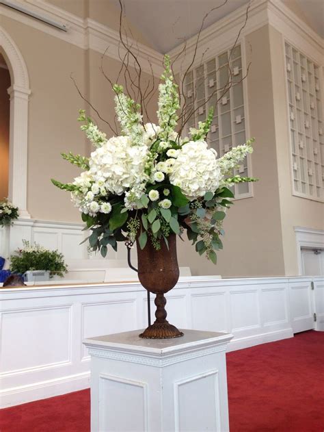 A Vase With White Flowers On Top Of A Pedestal