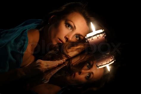 Portrait Of A Beautiful Woman With A Candle On A Black Background