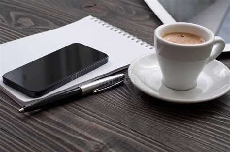 On The Desktop The Smartphone Notebook And Cup Of Coffee Stock Image