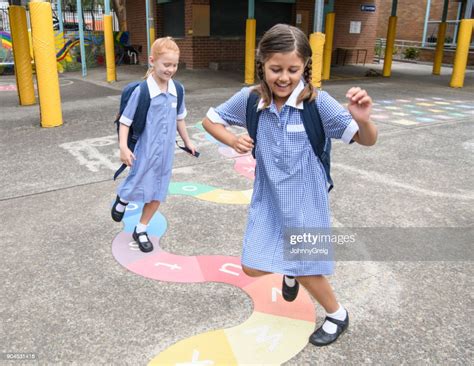 Two Young Girls In Uniform Playing In Schoolyard High Res Stock Photo