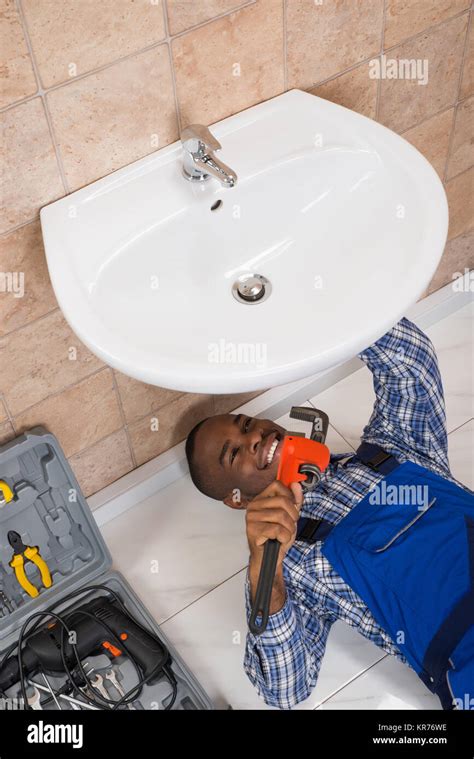 Plumber Fixing Sink In Bathroom Stock Photo Alamy