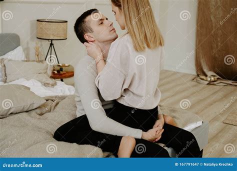Close Up Portrait Of A Beautiful Young Couple Hugs In Bed At Home Stock