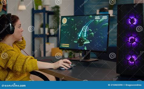 Focused Woman Gamer Sitting On Desk Putting On Headset Stock Footage