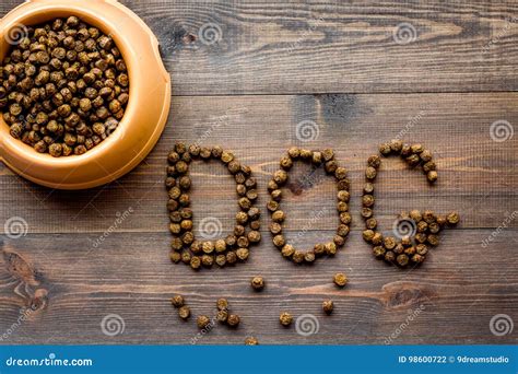 Dry Pet Dog Food In Bowl With Dog Text On Wooden Background Top View