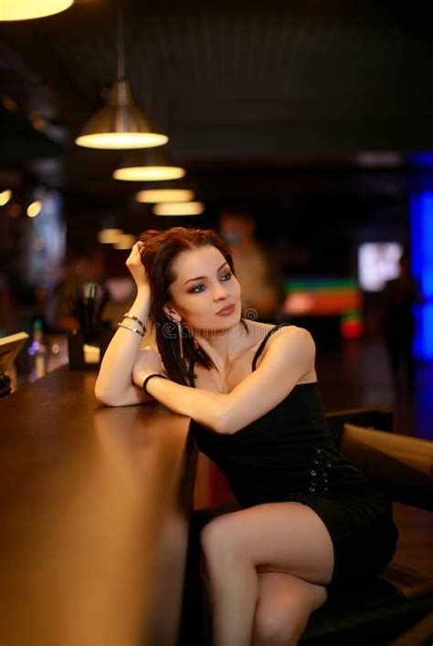 Beautiful Brunette Woman In Evening Dress Posing Near Bar Alone Stock