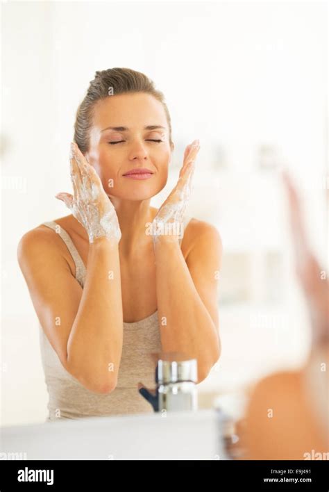 Young Woman Washing Face In Bathroom Stock Photo Alamy