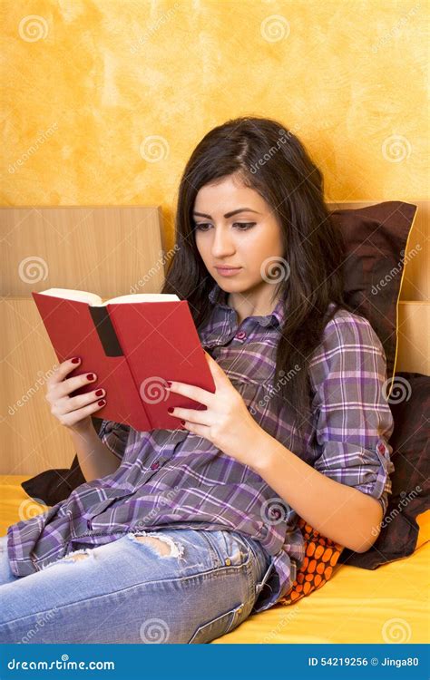 Geconcentreerde Tiener Die In Bed Liggen En Een Boek Lezen Stock Foto