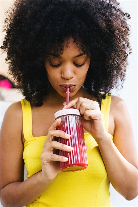 Afro Woman Drinking Delicious Smoothie In A Backyard On A Sunny Summer Day By Stocksy