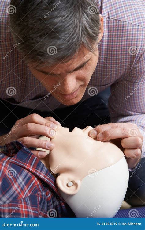 Man In First Aid Class Performing Mouth To Mouth Resuscitation O
