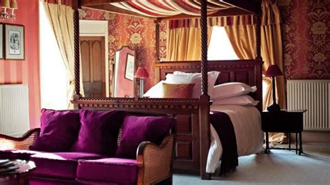 A Purple Couch Sitting Under A Canopy Bed In A Bedroom