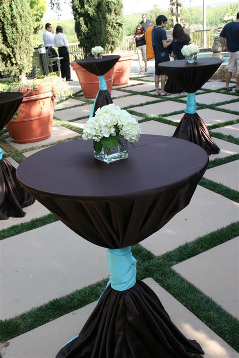 Tall Cocktail Tables With Chocolate Satin Table Cloths And Turquoise Satin Sashes Tied