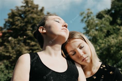 Lgbtレズビアンカップルの愛の瞬間の概念2人の若いレズビアンの女の子が抱き締めて屋外を幸せに歩く プレミアム写真