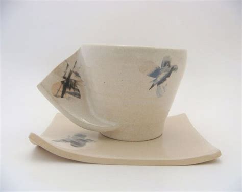 A Cup And Saucer Sitting On Top Of A White Plate With Blue Designs In