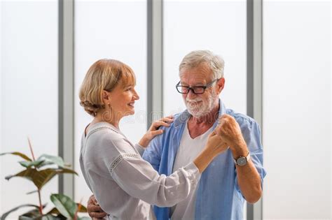 Portrait Of Happy Senior Couple Dancing In Living Room Elderly Woman