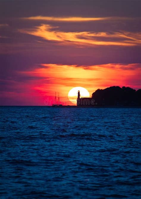 Sailboat And Lighthouse On Dramatic Sunset Stock Image Image Of