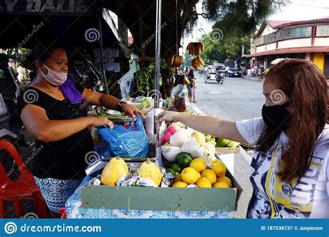 Customer Buy Fresh Fruit And Vegetable From A Vendor At Her Makeshift Stall Along A Sidewalk