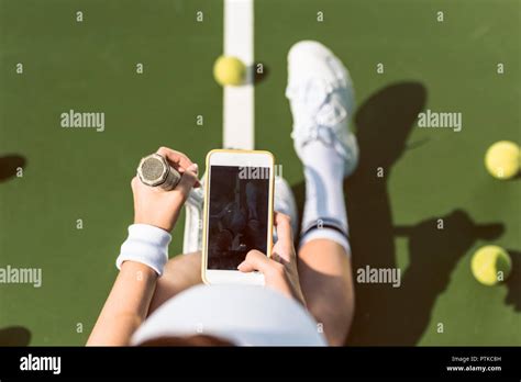 overhead view of female tennis player with racket taking picture of herself on tennis court