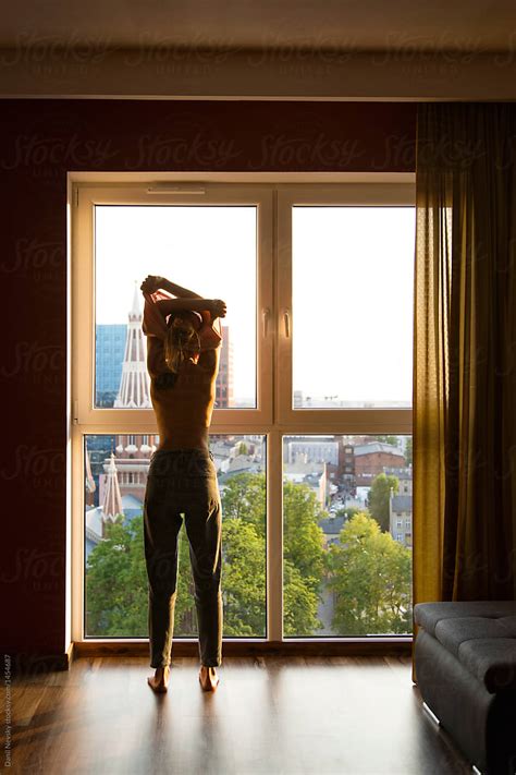 Woman Undressing In Front Of Window By Danil Nevsky Stocksy United