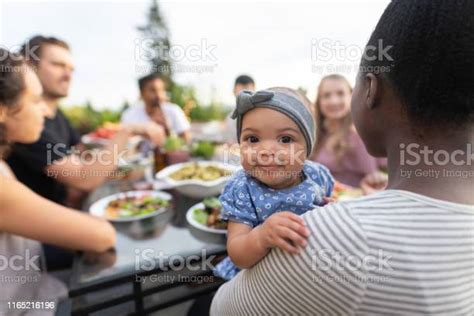 A Group Of Young Adult Friends Dining Al Fresco On A Patio Stock Photo