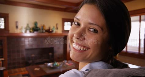 White Millennial Woman Sitting On Couch Smiling At Camera Stock Image