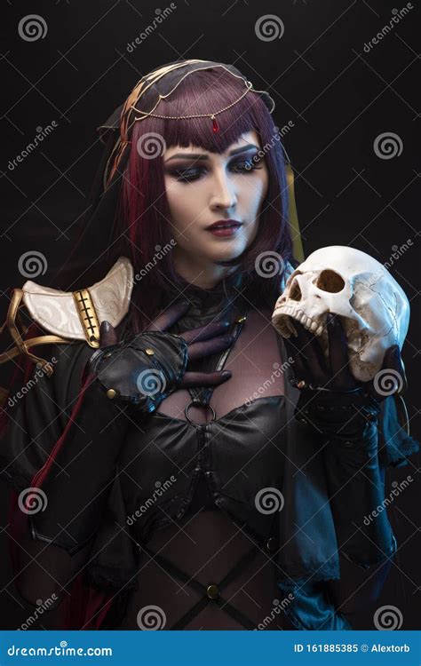 a beautiful leggy busty cosplay girl wearing an erotic leather costume poses holding fake human