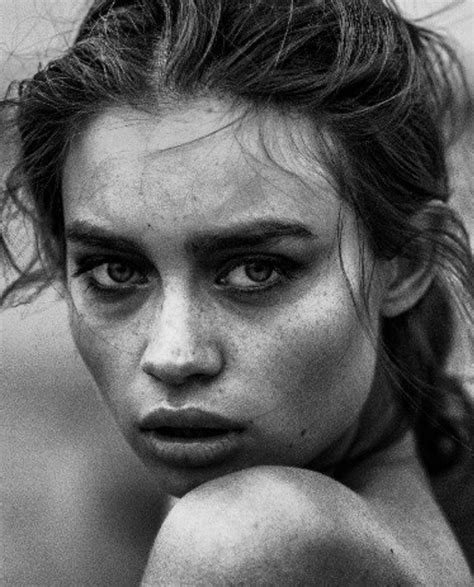 A Black And White Photo Of A Woman With Freckles On Her Face Looking At The Camera