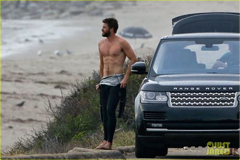 Liam Hemsworth Bares Ripped Abs While Stripping Out Of Wetsuit Photo