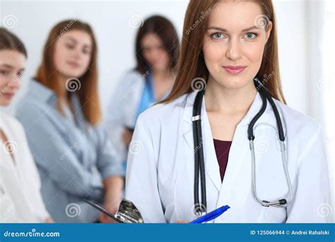 Young Beautiful Female Doctor Smiling While Consulting Her Patient