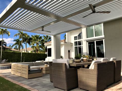 An Outdoor Living Area With Wicker Furniture And Palm Trees On The Side