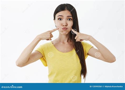 portrait of silly and cute asian girl in blue wig squinting and making funny faces showing