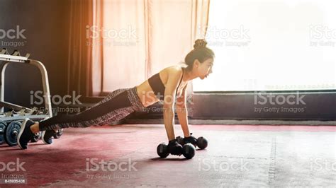 Asian Sports Woman Doing Exercises With Dumbbell And Pushups At The Gym