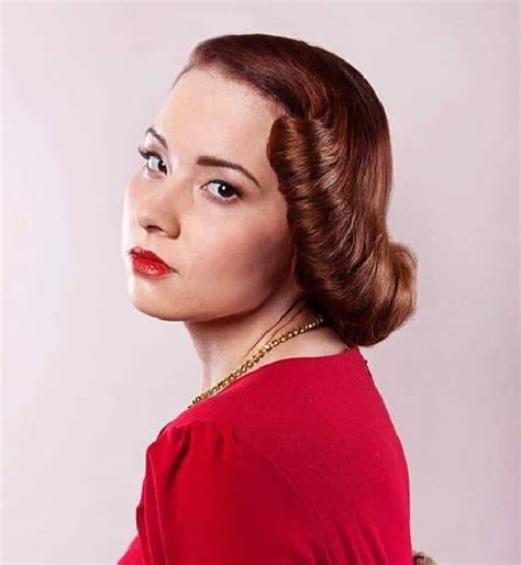 Younger women or those who favored longer hairstyles chose a basic combed curl set, or opted for a deep part to one side/center with hair pinned back past the temples. 20 Iconic 1940s Hairstyles for Classy Women - SheIdeas