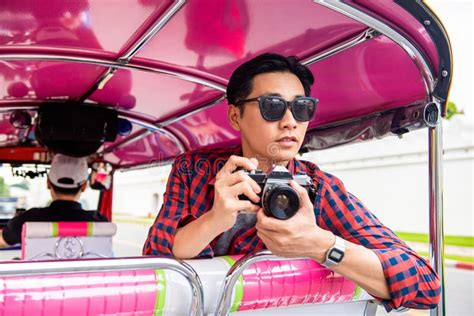 Handsome Male Asian Tourist Holding Camera On Tuk Tuk Taxi In Bangkok